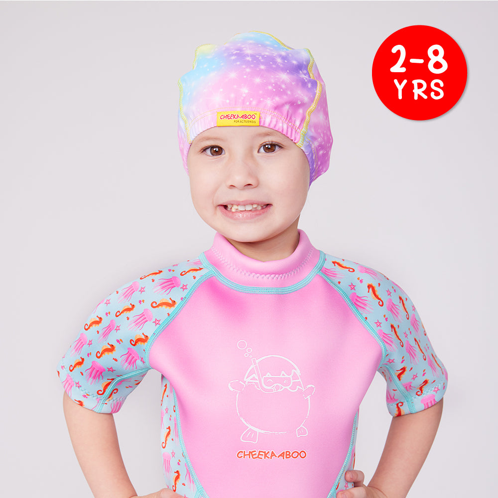 A kid wearing Cheekaaboo's Protective Toddler Swim Cap Magical Unicorn